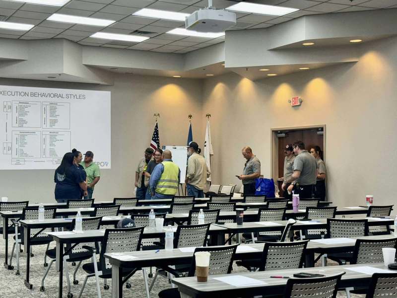 City of Altus employees standing at the front of a training room near a large screen with notes displayed.