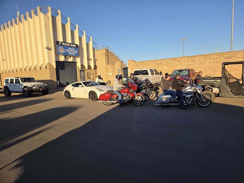 motorcycles lined up in a parking lot during sunset as part of a community birthday parade gathering in Altus.