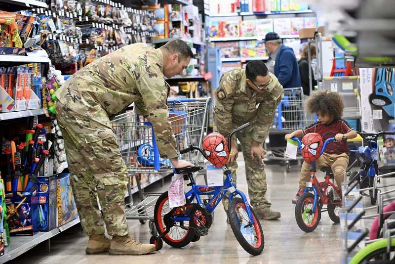 Children stand near bicycles during the Cops and Kids Christmas event as officers and volunteers assist.
