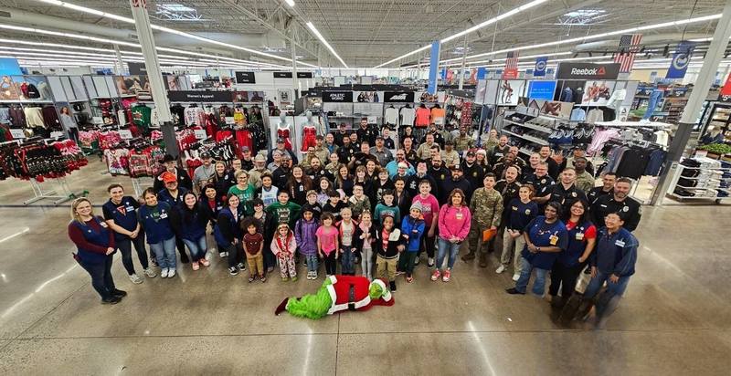 A large group of children and families attend the Cops and Kids Christmas event inside a walmart facility.