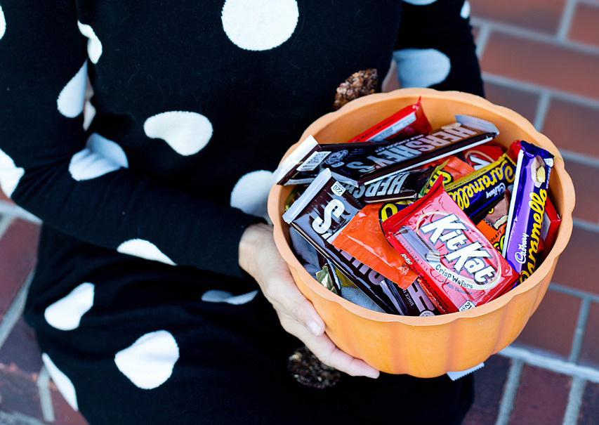 orange bowl with various candy bars in it