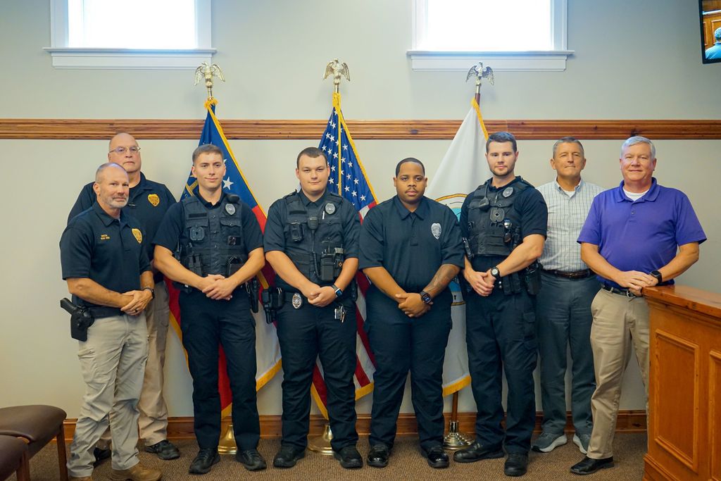 Newly sworn officers with city officials