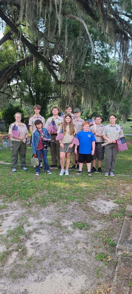 Group of scouts pose with flags in Oak City Cemetery 