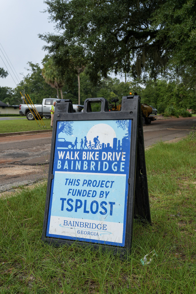 sign in grass that reads "walk bike drive Bainbridge This project funded by TSPLOST" city of bainbridge, ga logo