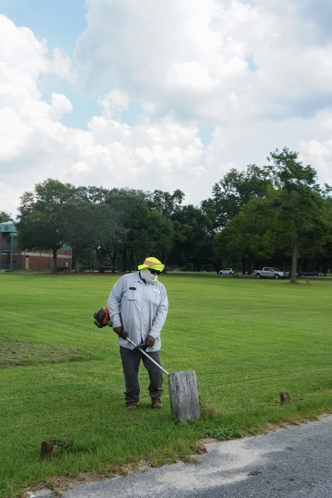 City of Bainbridge parks department employee weed eating at Earle May Boat Basin