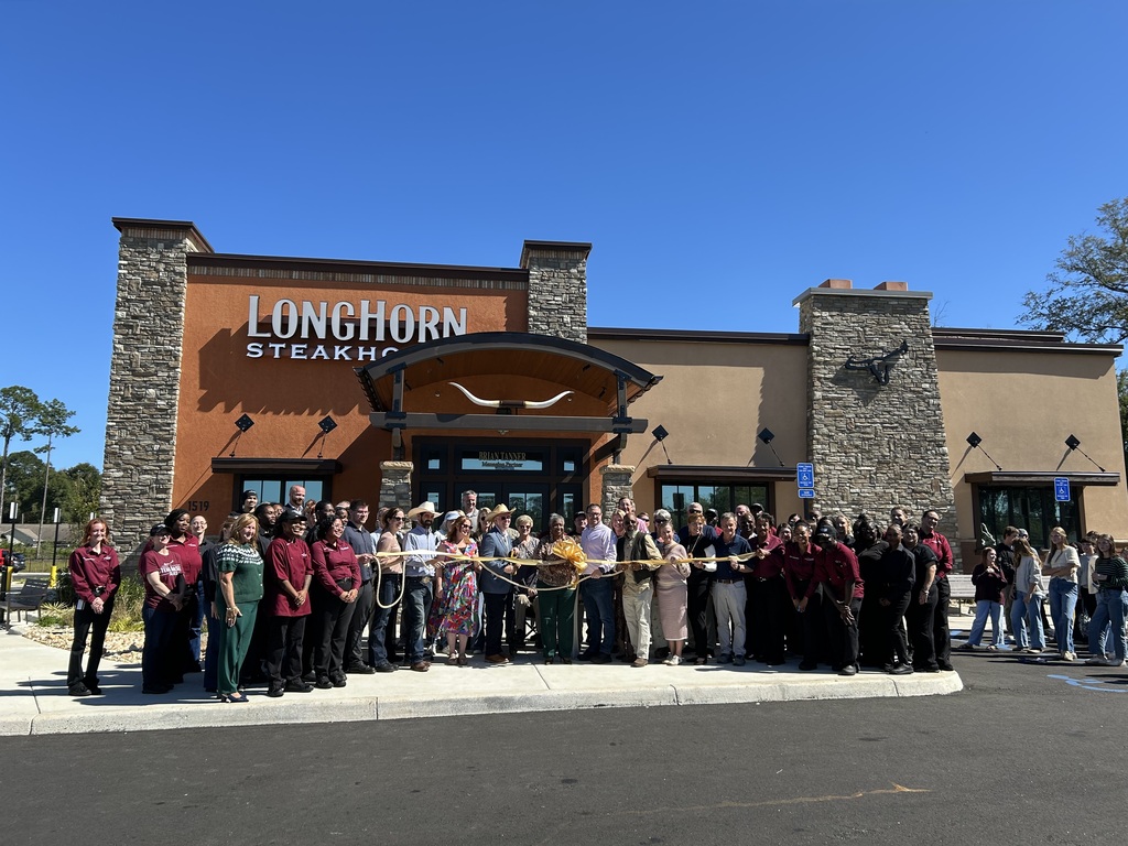 crowd stands in front of longhorn steakhouse in bainbridge for ribbon cutting