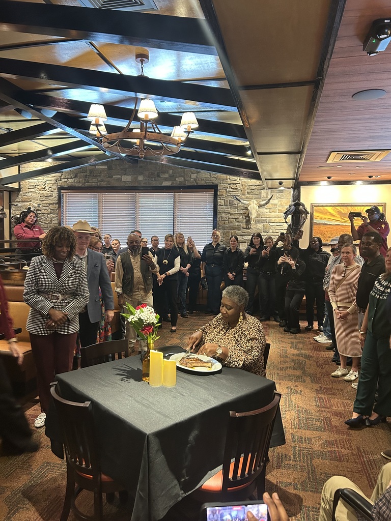 crowd stands in longhorn steakhouse mayor sylvia washington pictured center cutting a steak