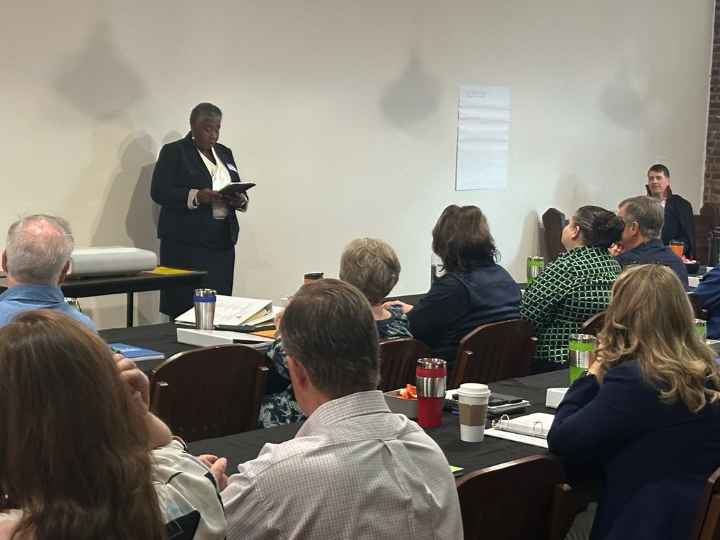 Mayor Sylvia Washington delivers welcoming remarks to attendees of the Georgia Department of Community Affairs Community Planning Institute in Bainbridge. Participants are seated at tables with notebooks and informational materials as they listen to the mayor.