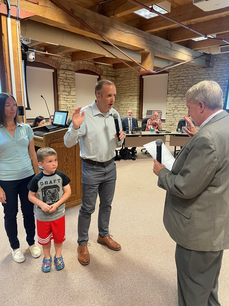 Bob White with hand raised, his wife and son by his side. Mayor delivers oath