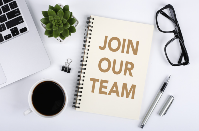 Join Our Team Graphic of a notebook on a desk with other office supplies