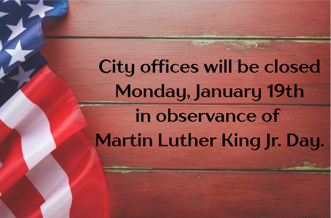 American flag on a wooden surface beside text: "City offices will be closed Monday, January 19th in observance of Martin Luther King Jr. Day."