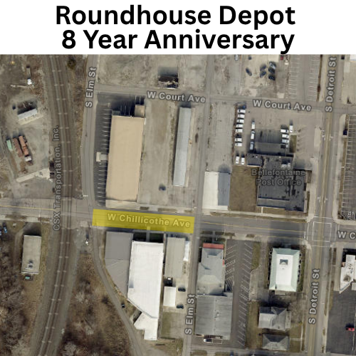 Aerial/satellite view of an urban industrial area with streets labeled W Chillicothe Ave, S Elm St, W Court Ave, and S Detroit St. Several warehouse-style buildings, parking lots, railroad tracks, and a post office building are visible near an intersection.