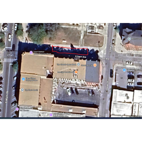 Aerial view of a city block, showing buildings, parking lots, and streets with labeled names: E Court Ave, Main St, and Georgia St. Urban infrastructure.