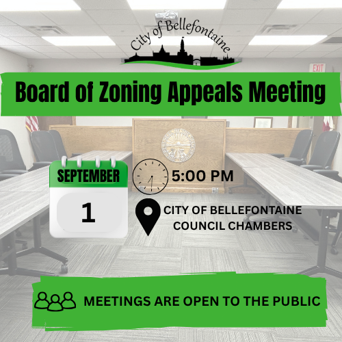 Empty conference room with tables and chairs, a clock, and a sign. Date, time, and location of the Board of Zoning Appeals Meeting.