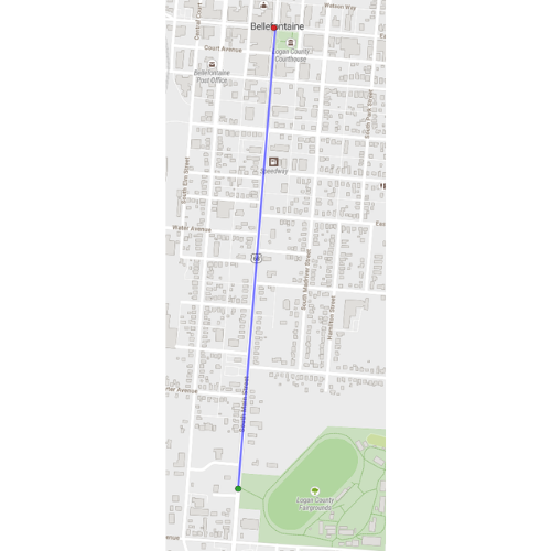 Urban map with a blue line marking a route. Green shapes represent parks. Buildings and roads shown in gray.