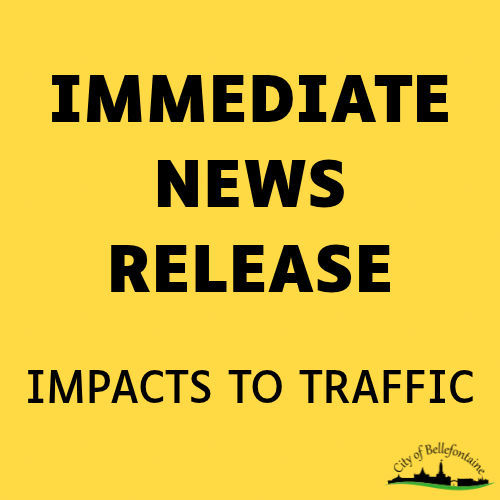 A yellow poster with black text reads "Immediate News Release" and "Impacts to Traffic." Below the text, there is a logo.