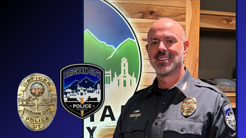 Chief Reyes stands near a large lighted Brigham City logo sign