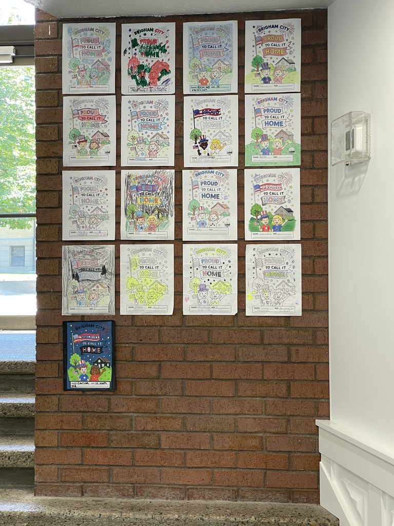 coloring contest submissions displayed on a brick wall