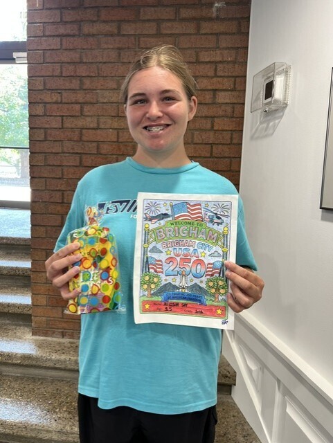 Allison holding her prize and the picture she colored