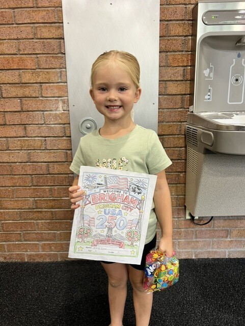 Riley holding her prize and the picture she colored