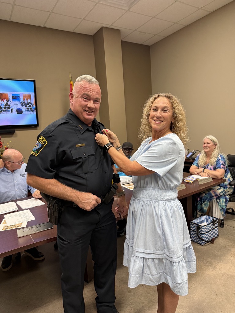 chief of police and his wife pinning on his badge