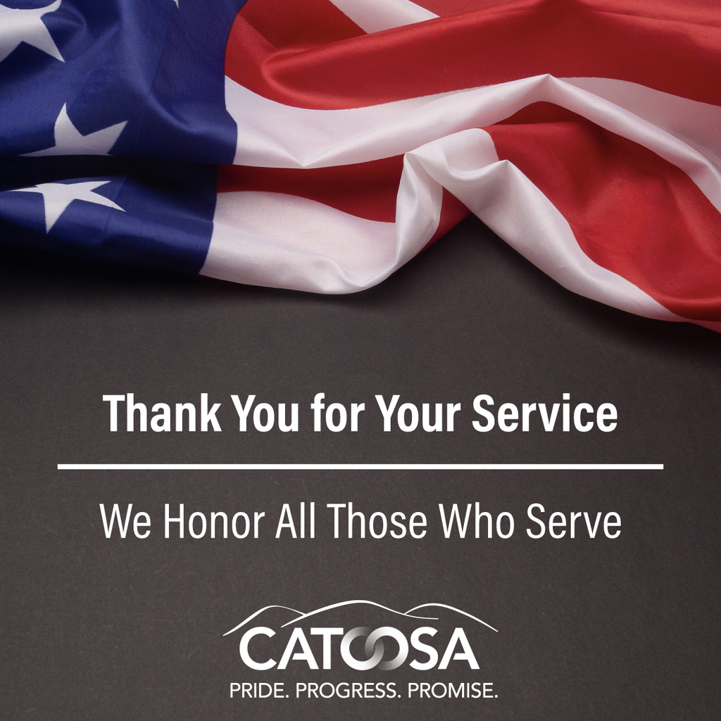 An American flag laying on a table, with text reads "Thank you for your service --- We honor all those who serve" with the logo for Catoosa below.