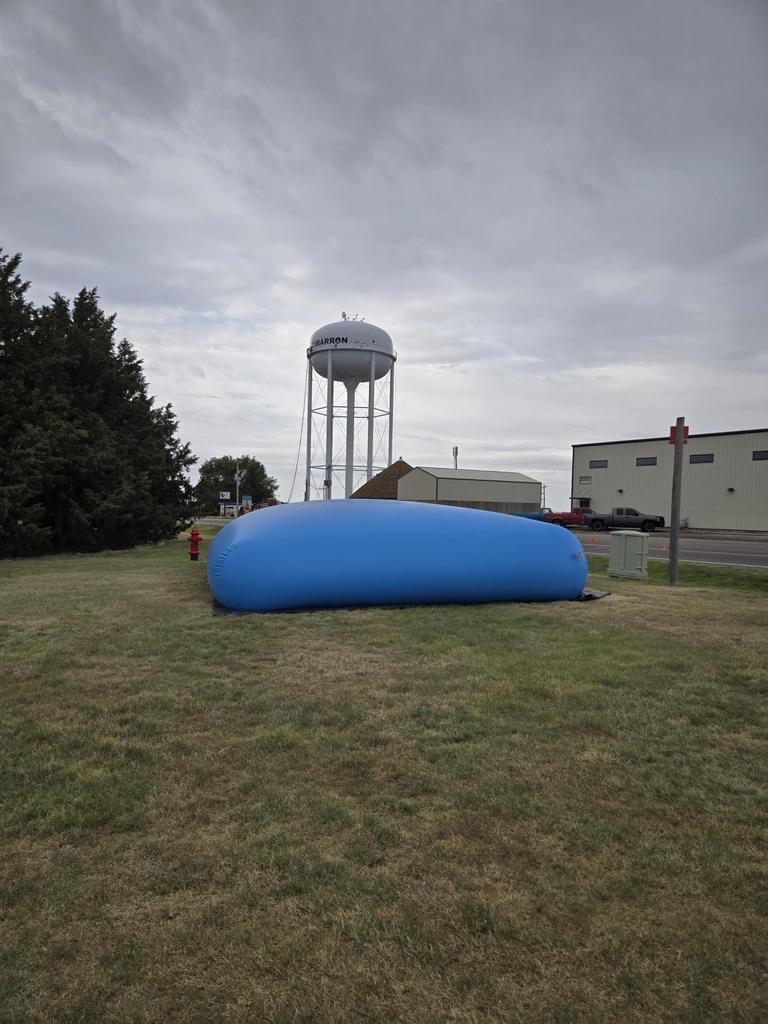 Blue Water Bladder in front of Water Tower
