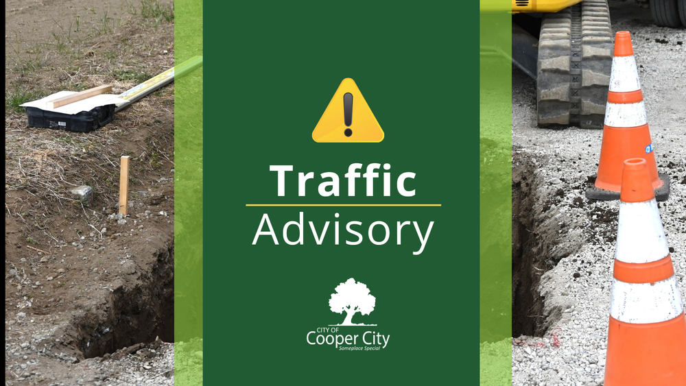 Backhoe digging in to the ground and traffic cones surrounding a hole in the ground