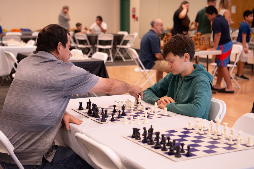 Image depicts man and boy playing chess