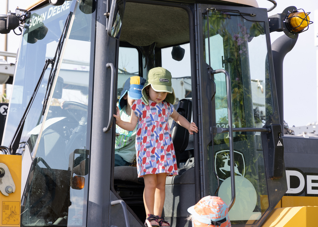 Image depicts child on a bulldozer during Touch-A-Truck event.