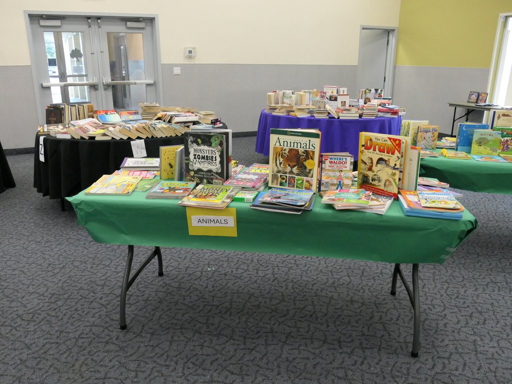 Image depicts a table with several books on it.