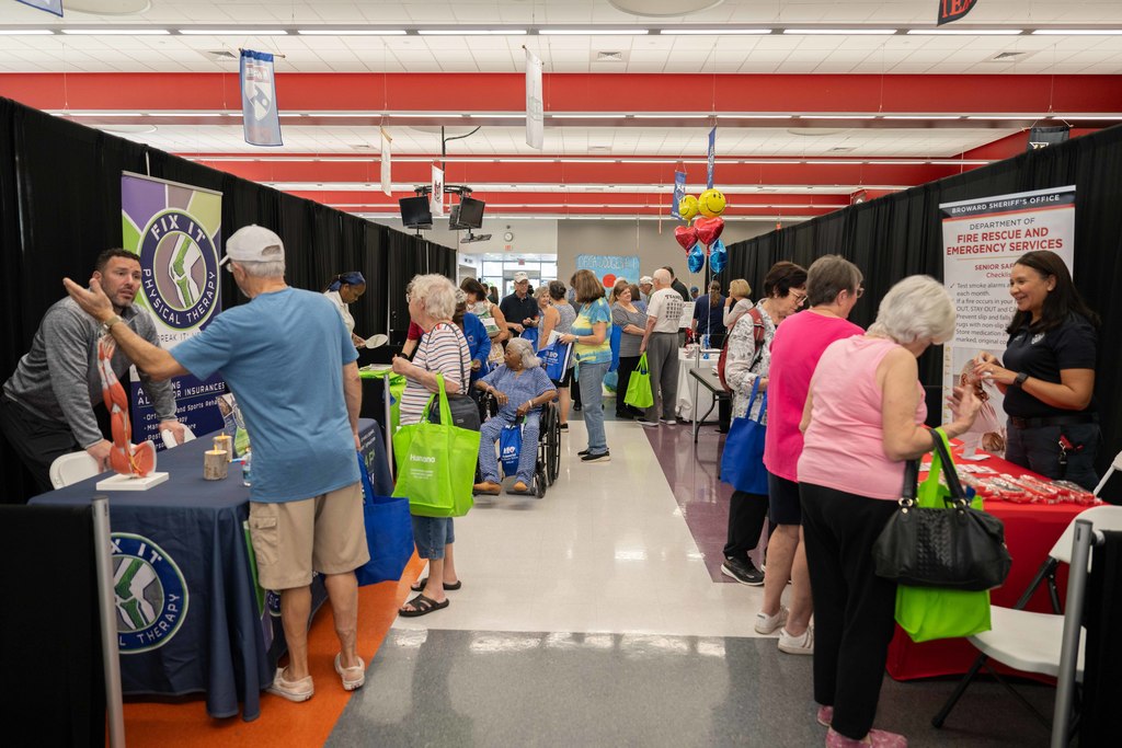 Vendors behind tables and prospective clients speaking to them.