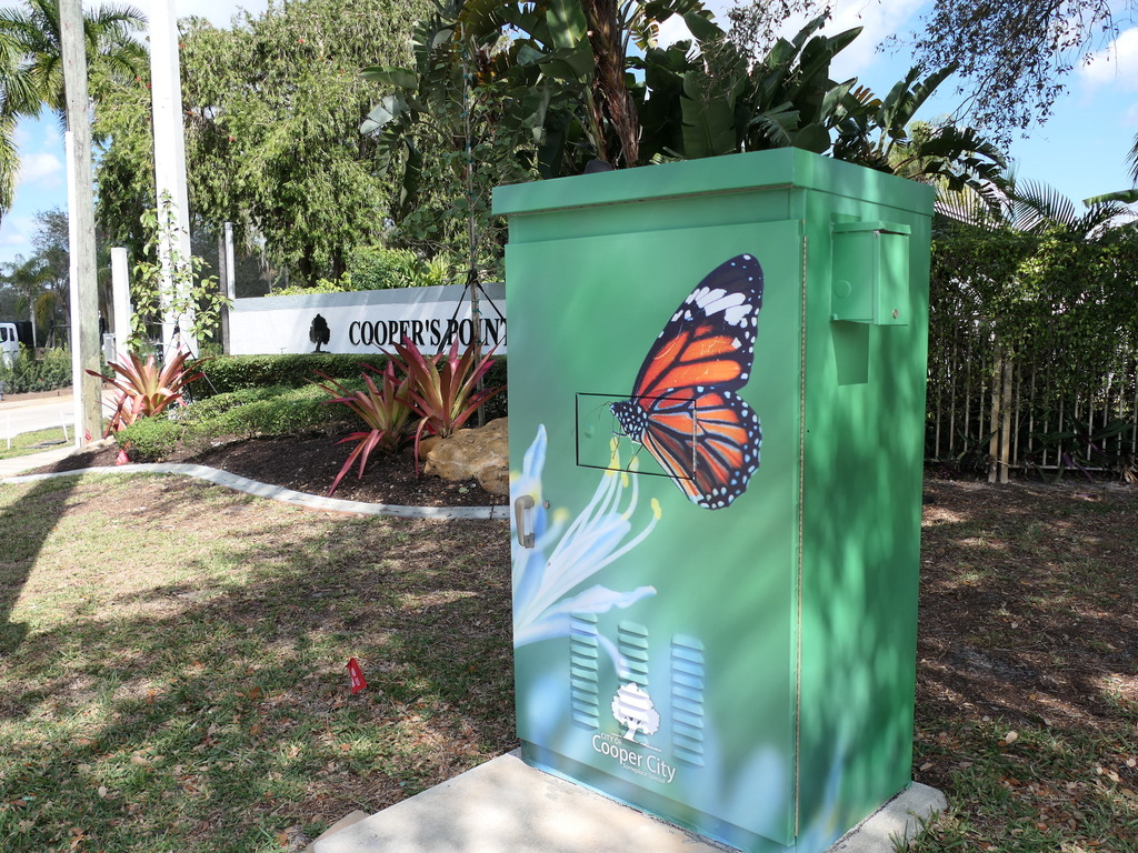 Utility box wrapped with artistic design of monarch butterfly on a flower