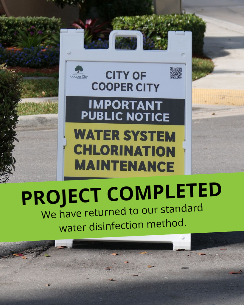White sandwich board sign, placed along a roadway, with important public notice about water system chlorination maintenance.