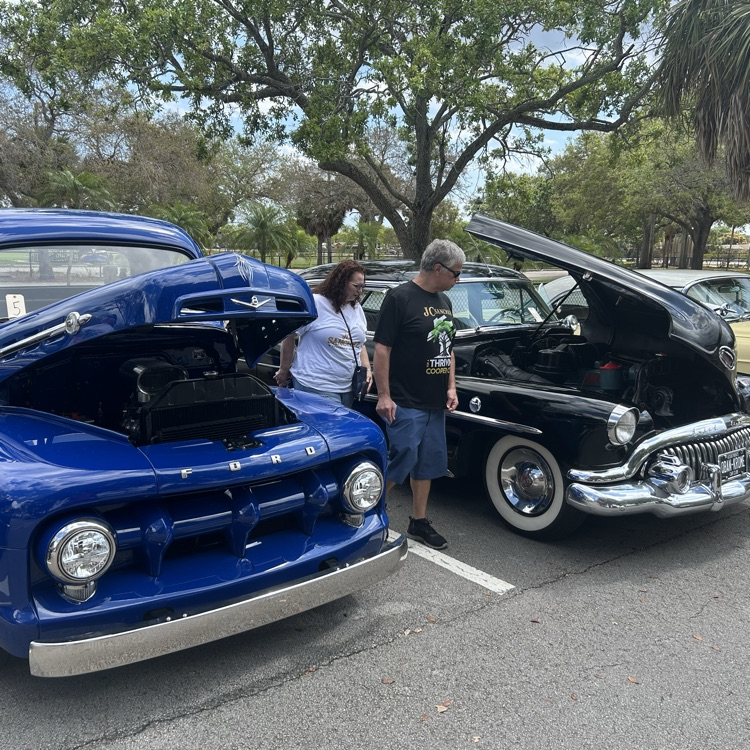 Man and woman looking at a classic car