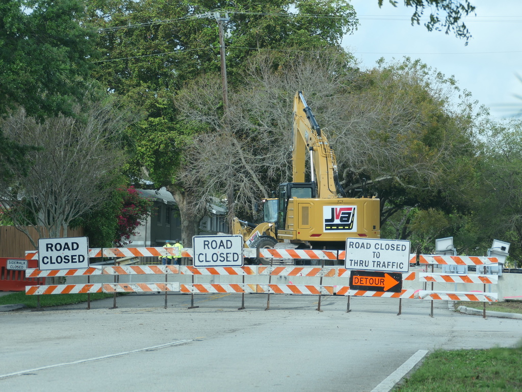 Large construction equipment and "Road Closed" signs