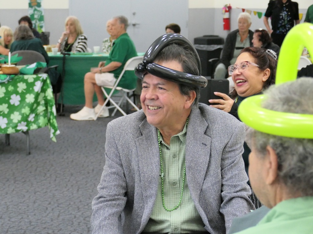 Man smiling with a balloon wrapped around his head.