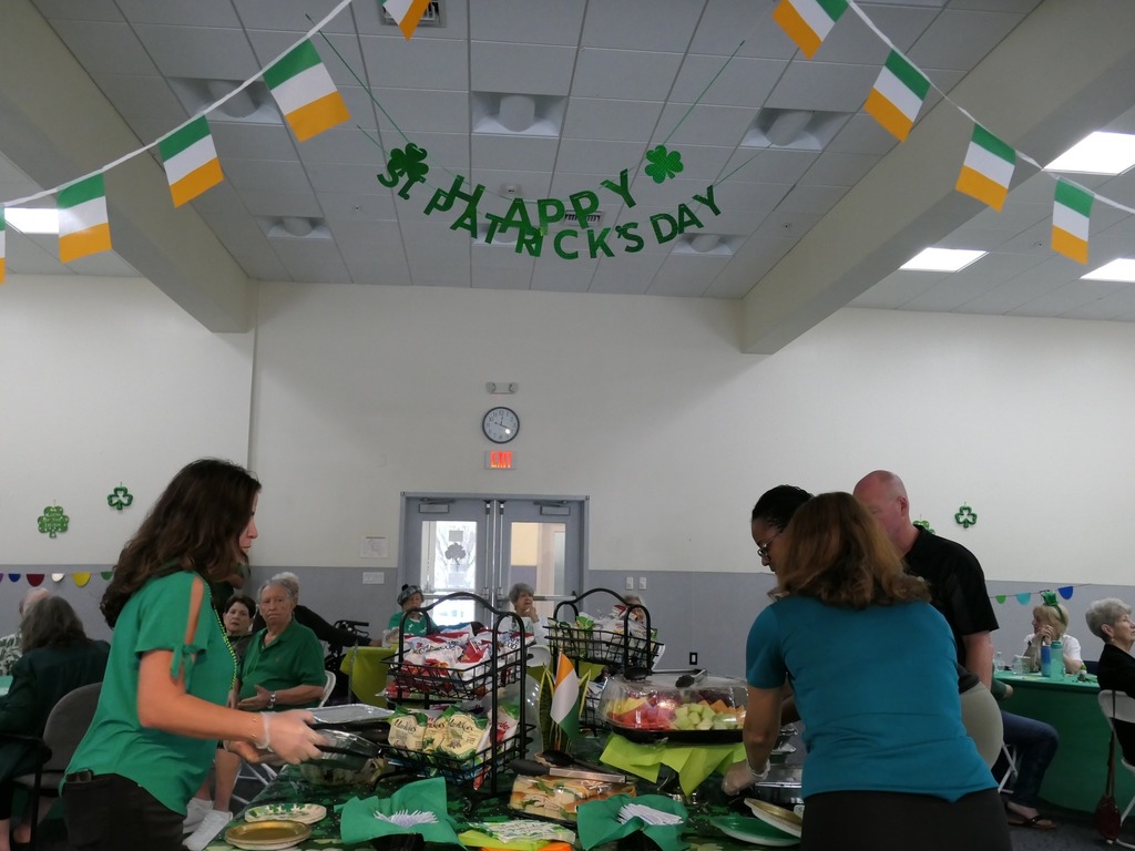 Table filled with snacks and three women organizing the table.