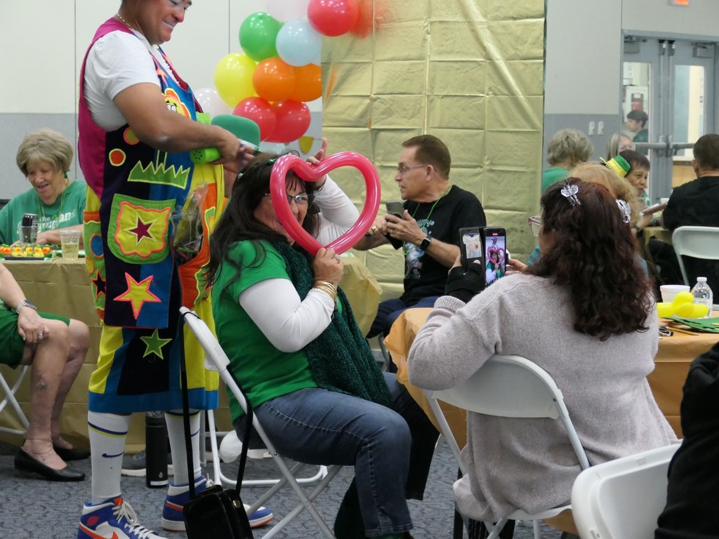Woman holding a balloon in the shape of a heart to her face.