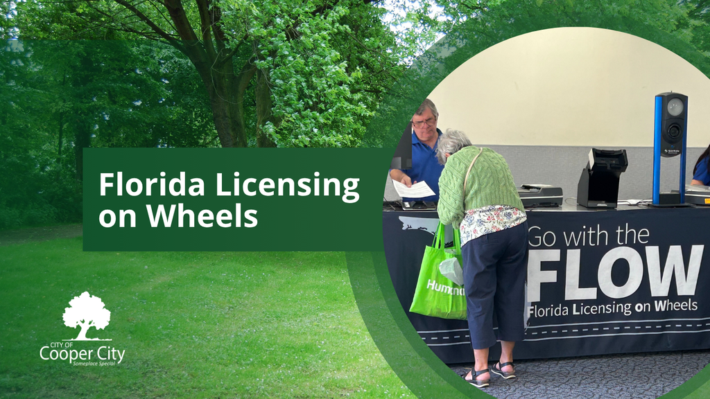 Counter with a man providing a woman with assistance, a tablecloth with the words "Florida Licensing on Wheels."