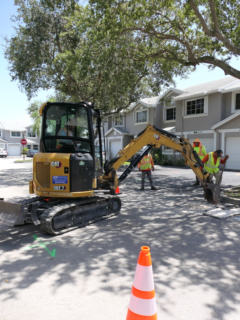 Construction workers digging a hole for water service line replacement project in Cooper City.