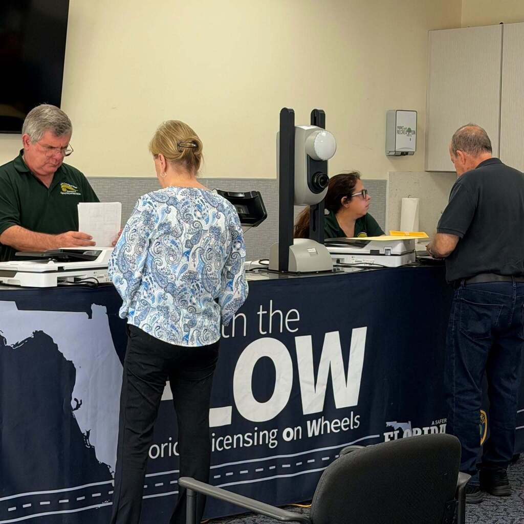 Customer service representatives assisting customers during a Florida Licensing on Wheels event in Cooper City.