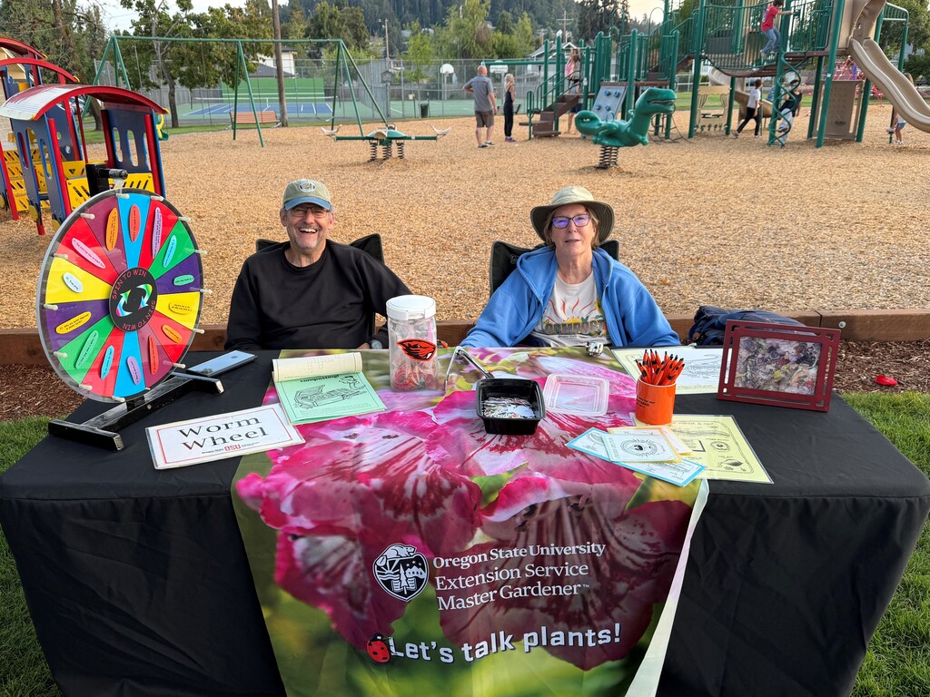 Image of Stewart and Bonnie Samuels hosting the Oregon State Master Gardeners booth at Creswell's Movies in the Park event