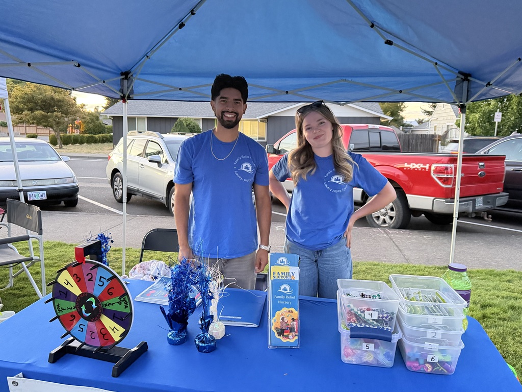 Image of two employees from the Family Relief Nursery hosting a booth at Creswell's Movies in the Park events.