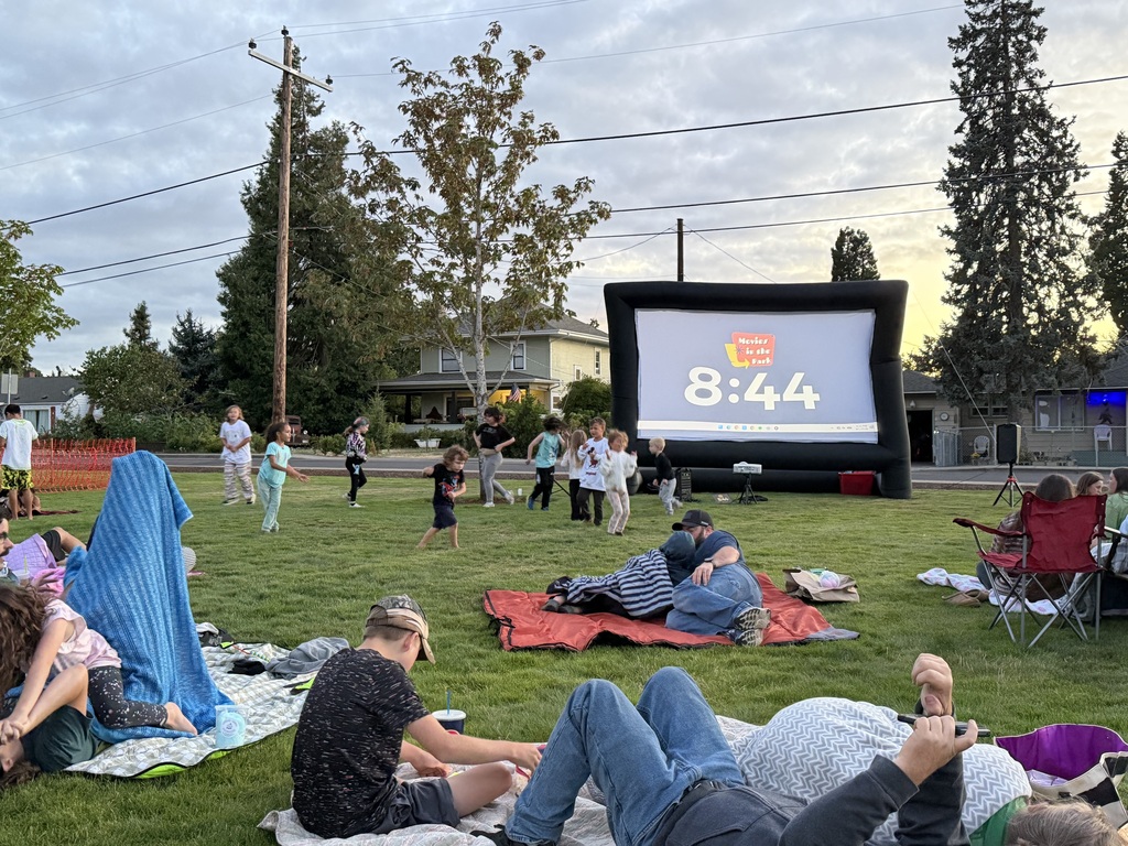 Image of children dancing and having fun in front of the inflatable movie screen at Creswell's Movies in the Park
