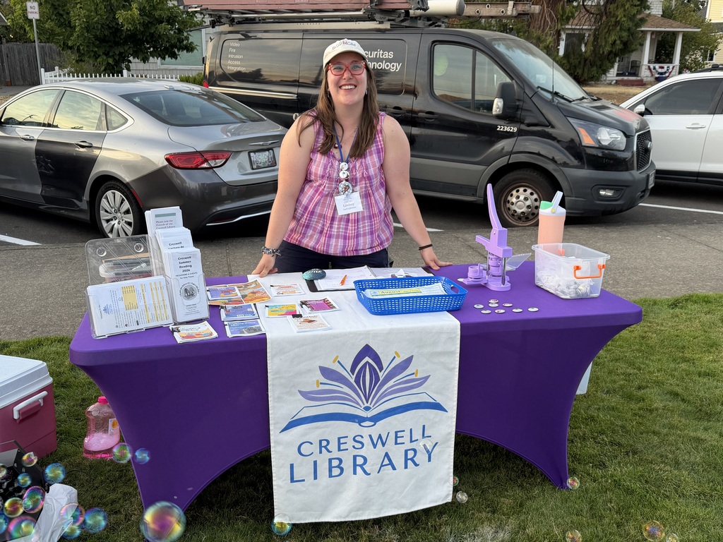 Image of Lindsey Quigley-Johnson, the youth librarian for the Creswell Library, at the Creswell Library booth at Creswell's Movies in the Park event
