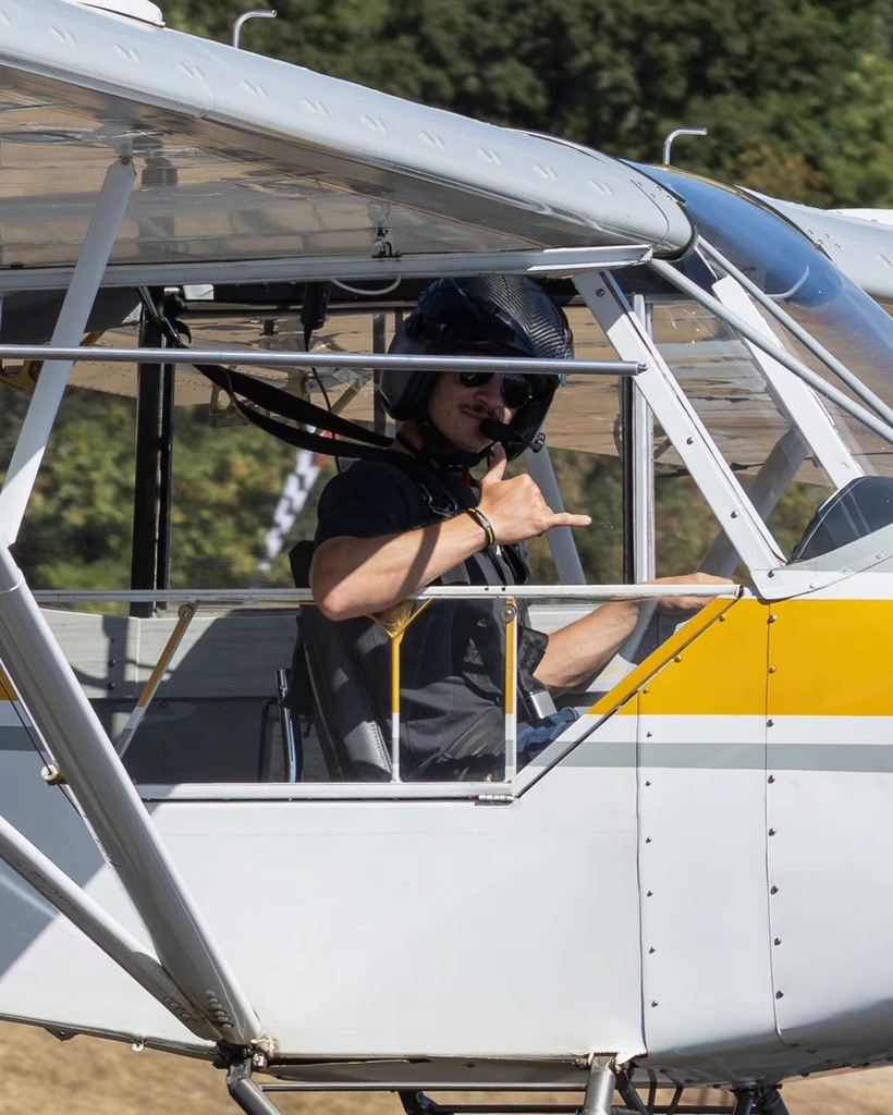 Image of one of the Creswell STOL pilots giving the "hang ten" gesture as he prepares for takeoff