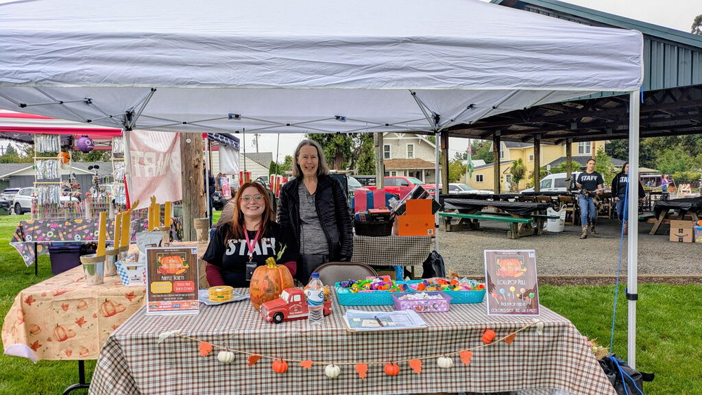 Image of City of Creswell Administrative Assistant Heather Prociw and Creswell City Councilor Joan Morris at the Creswell booth at the Creswell Fall Festival.