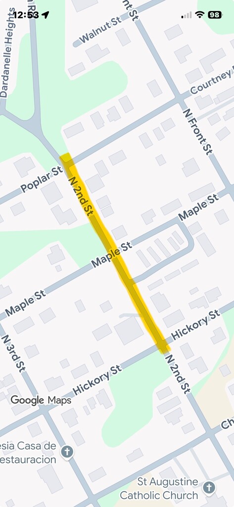 Screenshot of a Google Maps view showing a highlighted construction area along North 2nd Street in Dardanelle, Arkansas. The highlighted section extends from the Poplar Street intersection south to the Hickory Street intersection, passing through Maple Street. Nearby streets include Walnut Street, Courtney Street, North Front Street, and North 3rd Street. Surrounding residential buildings, green spaces, St. Augustine Catholic Church, and Iglesia Casa de Restauración are visible on the map. The highlighted route is shown in yellow to indicate the active construction area.