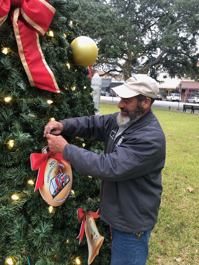 City workers hang the sponsored ornaments on the Christmas tree